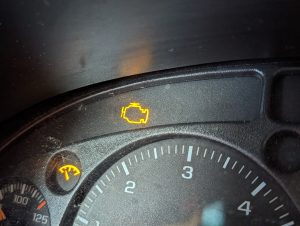 A vehicle dashboard with check engine light on